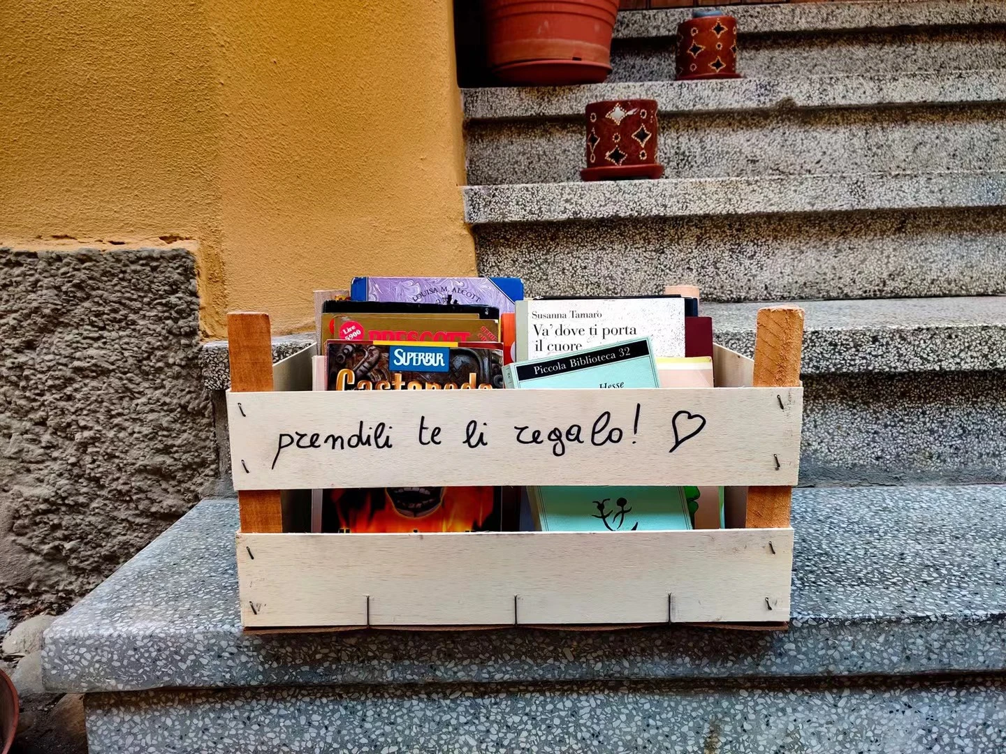 A small box of books beside stone steps