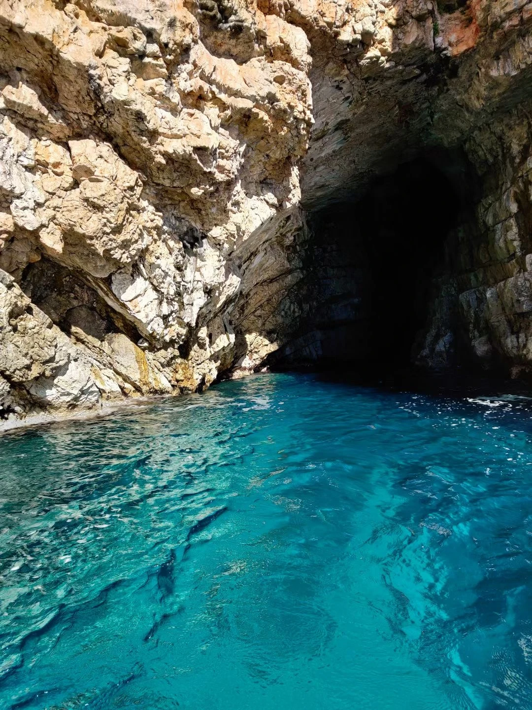 Clear turquoise water below a rocky cliff