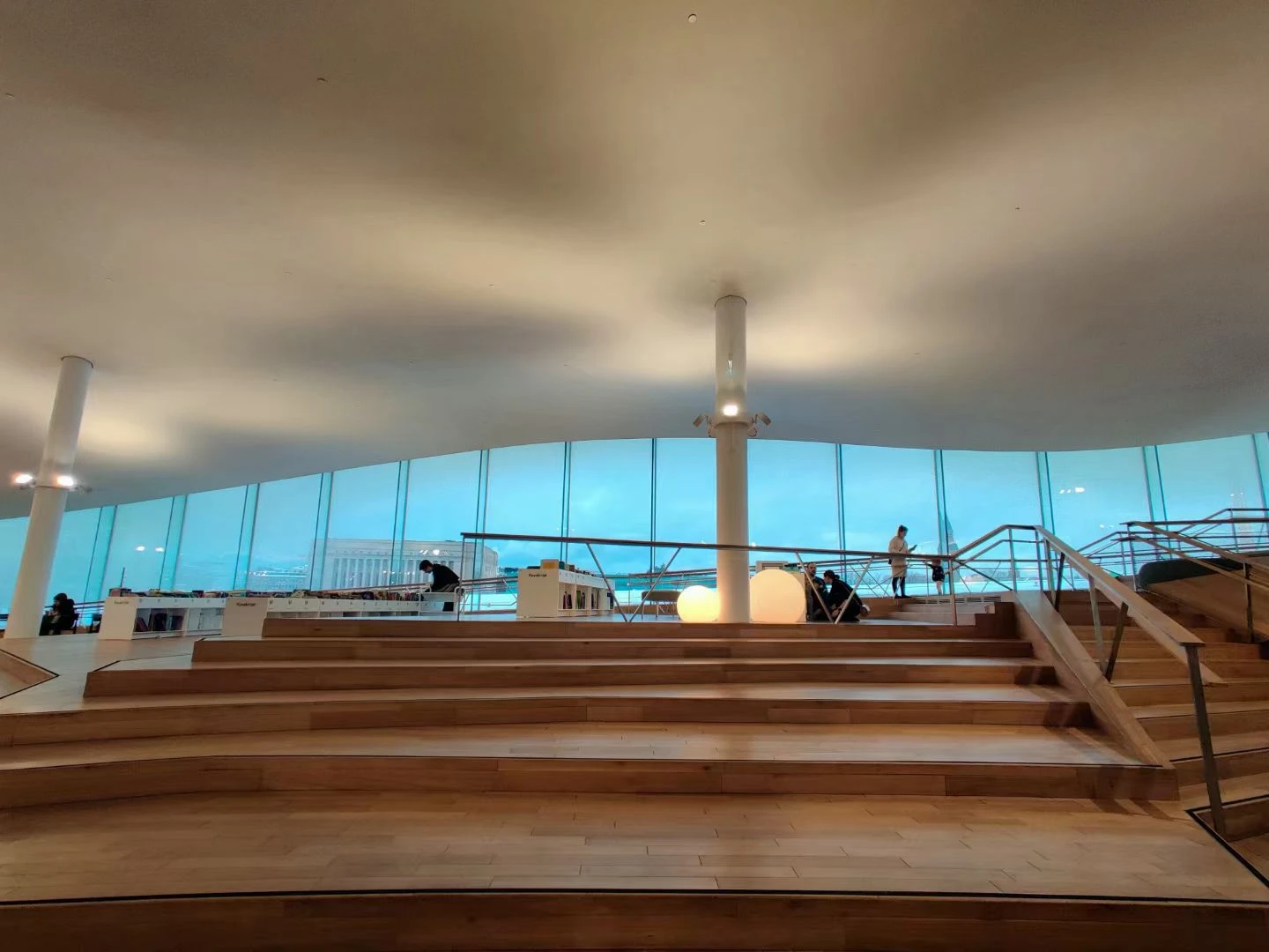Wide wooden steps and blue windows in a light-filled interior